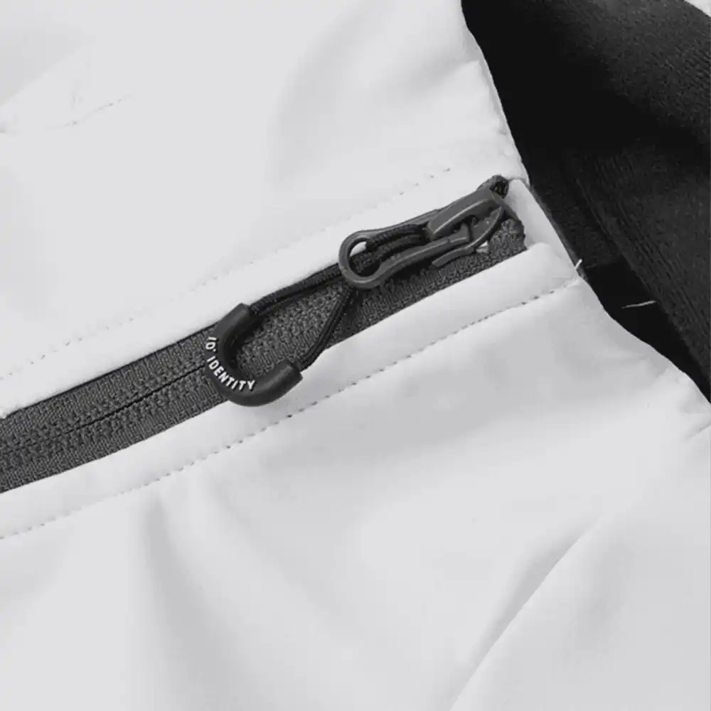 Valkoinen CORE soft shell takki yksityiskohtakuva – vetoketju, ompeleet ja kaulus logolla