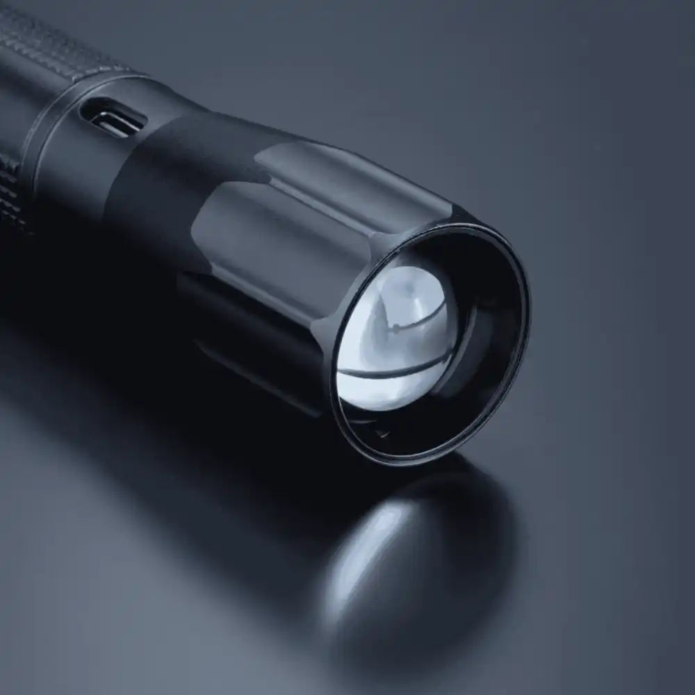 Lähikuva Optima Medium -taskulampun linssistä ja säädettävästä zoom-valokeilasta