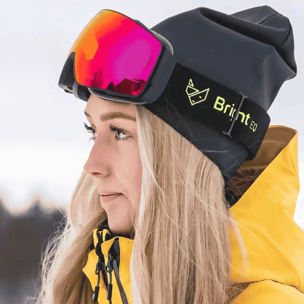 Nainen laskettelurinteessĂ€ Bright Equipment -magneettilaseilla, REVO-linssi kĂ€ytössĂ€ â tyylikĂ€s joululahja