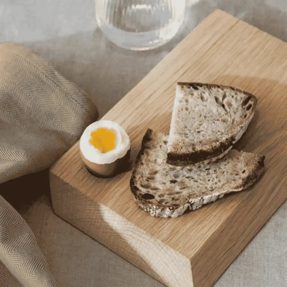 Pieni Ekta Living tammileikkuulauta aamiaiskäytössä leivän ja kananmunan kanssa – kaunis henkilöstölahja