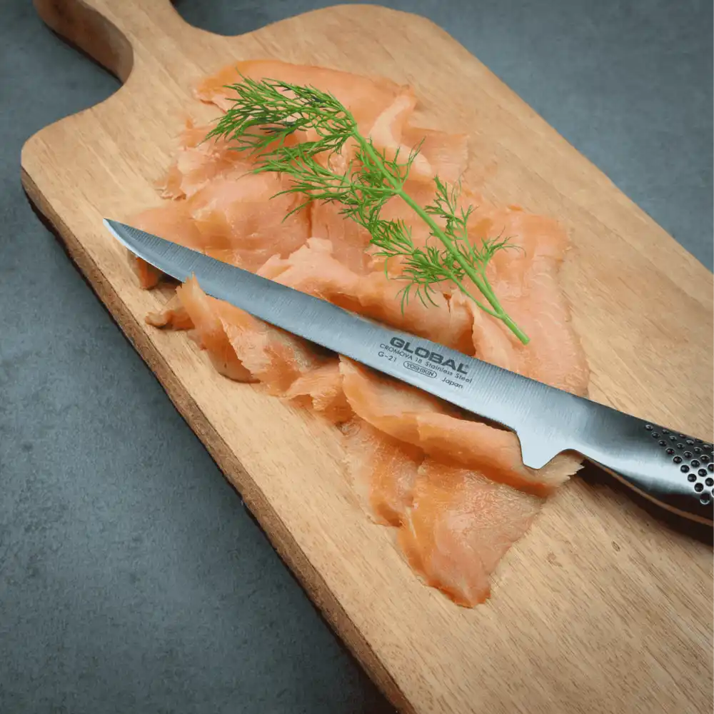 Joululahja idea. Global G-21 fileointiveitsi leikkaamassa graavilohta Global tammileikkuulaudalla