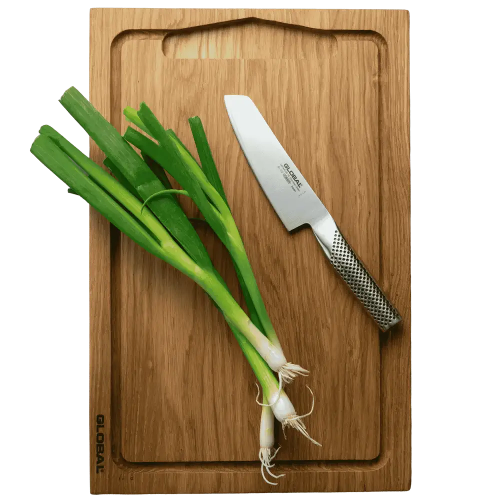 Global tammileikkuulauta käytössä Global-veitsen ja purjosipulin kanssa