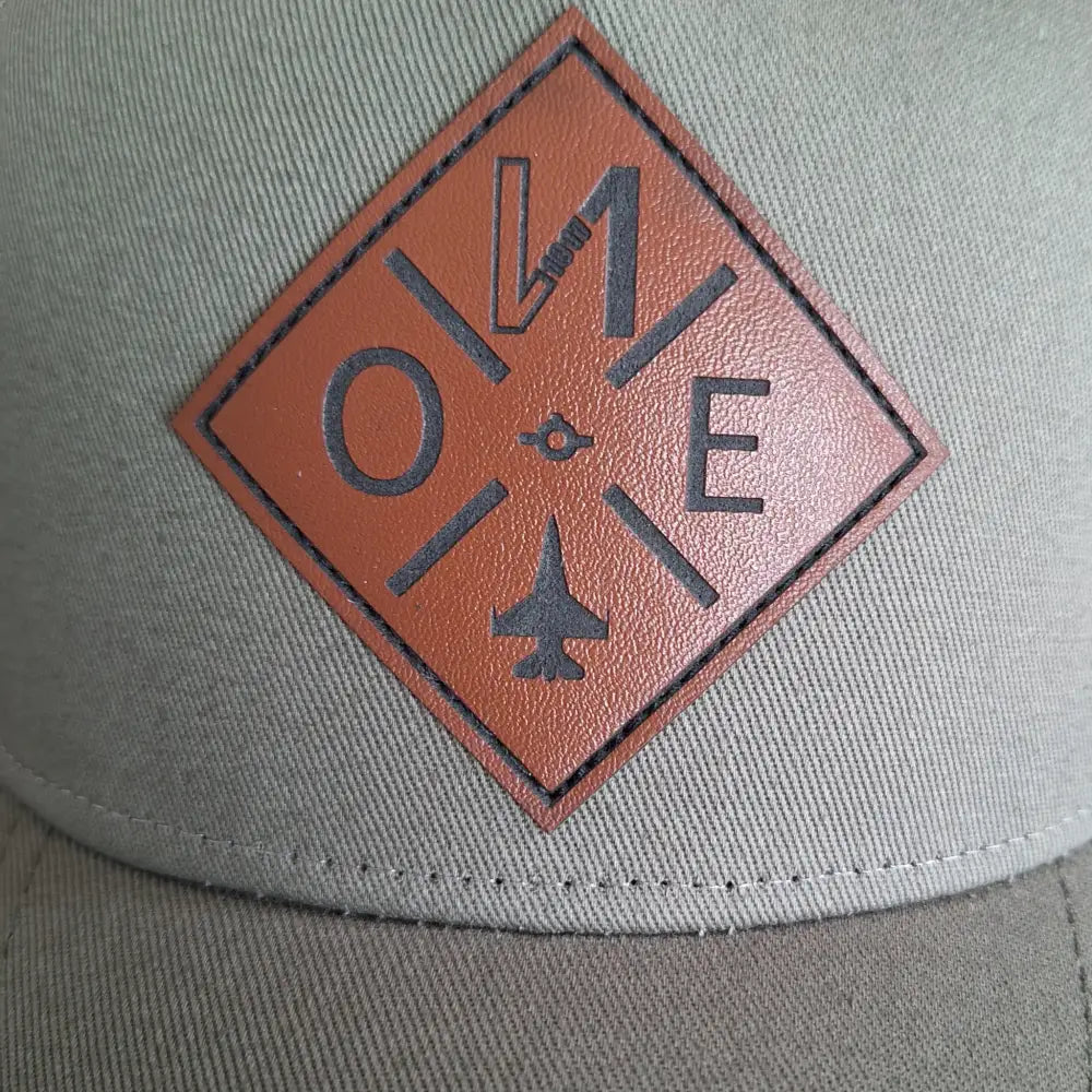 Lähikuva nahkamerkillä tehdystä logosta lippalakkiin.