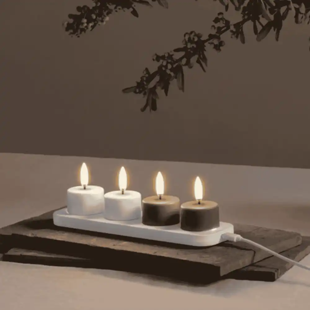 Neljä Uyuni LED-kynttilää latautumassa pienellä Uyuni-latausalustalla – kätevä liikelahjasetti