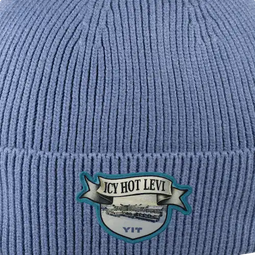 Pipo omalla logolla – painettu kangasmerkki ommeltuna pipoon, monivärinen ja tarkka toteutus