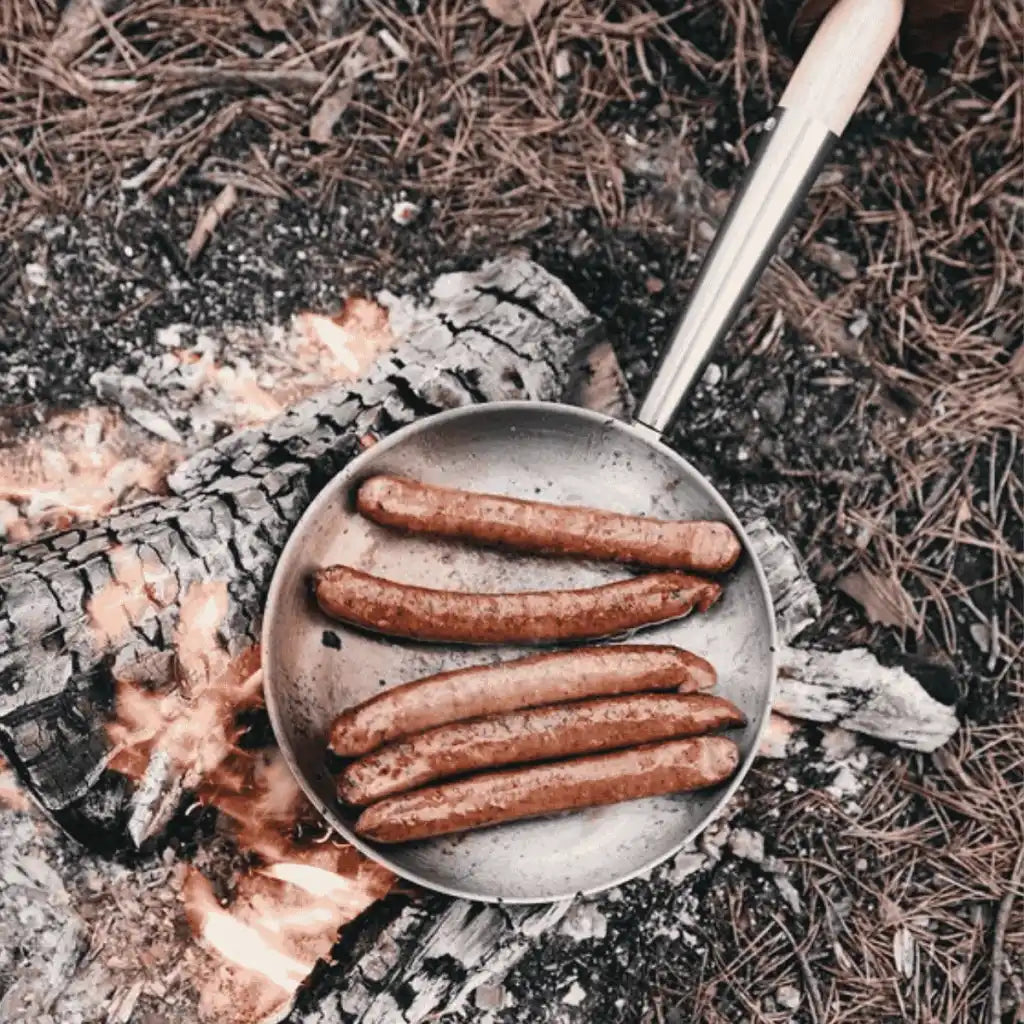 Makkaranpaistoa nuotiolla Vinga Vici eräpannulla ylhäältä kuvattuna – loistava kesälahja