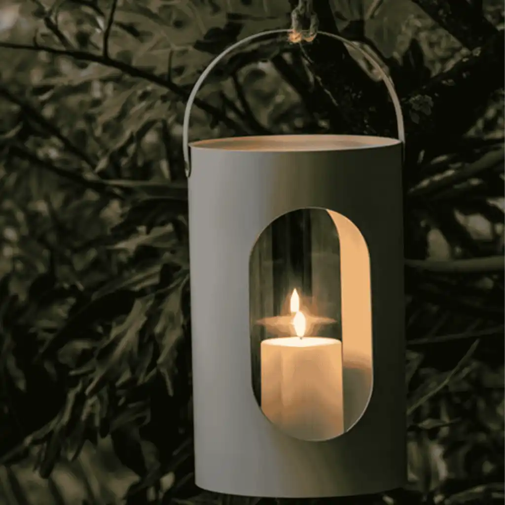Musta Ekta Living Light House -lyhty luomassa tunnelmaa ulkona kynttilän palaessa – elegantti kesä- tai joululahja