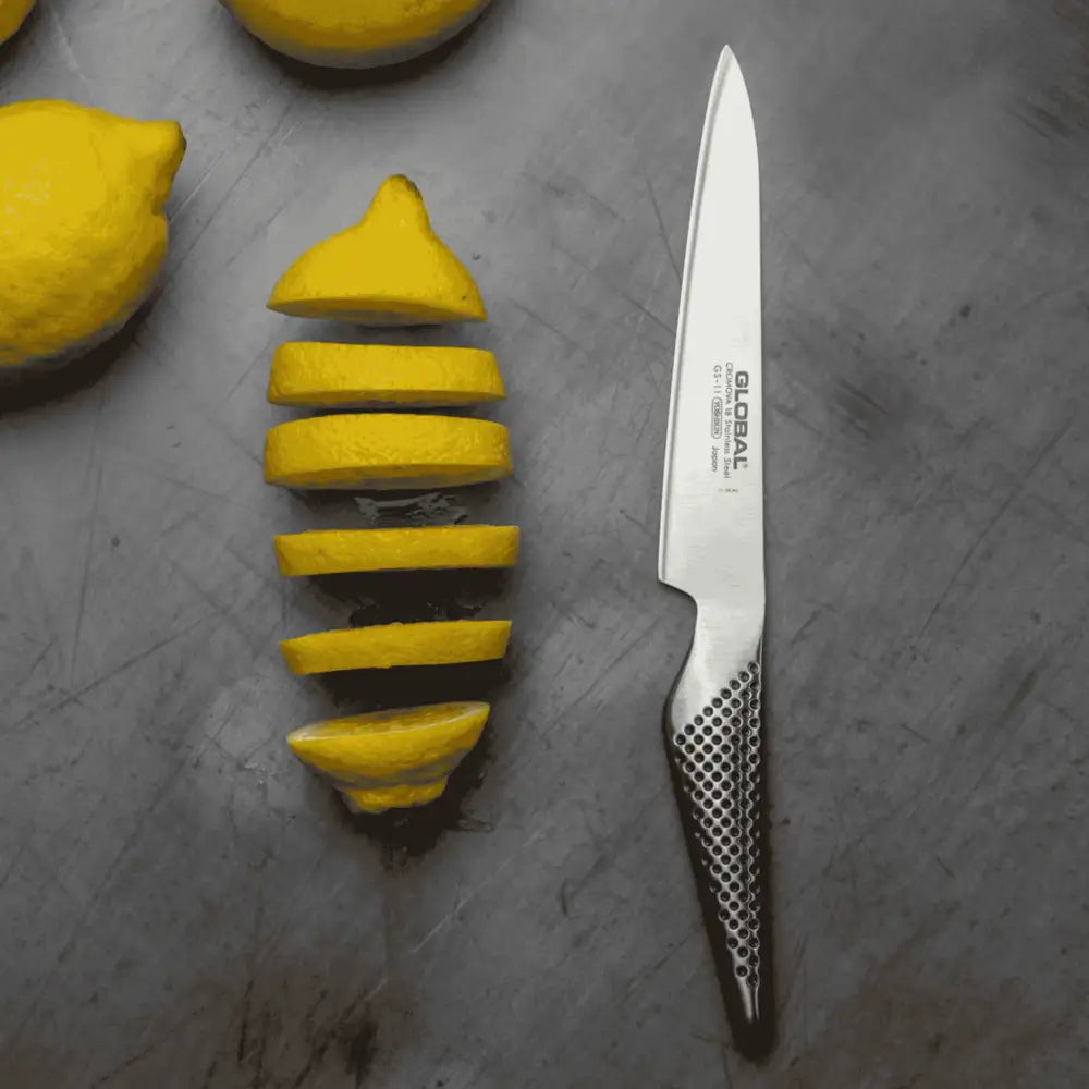 Global GS-11 veitsellÀ leikataan tarkasti sitrushedelmÀÀ Global tammileikkuulaudalla