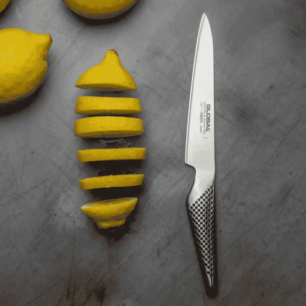 Global GS-11 veitsellä leikataan tarkasti sitrushedelmää Global tammileikkuulaudalla