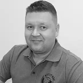 Musta-valkoinen muotokuva henkilöstÀ, joka pukeutuu kauluspaitaan, jossa on logo.