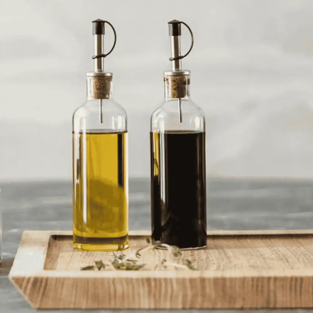 Ekta Living öljy- ja etikkapullot käytössä Ekta Living tammileikkuulaudalla – elegantti lahjasetti