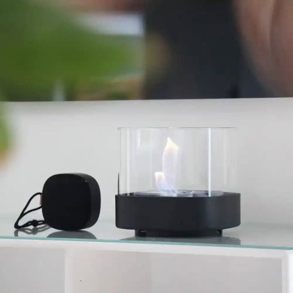 SACKit Bio Lamp Ø14 luomassa lämmintä tunnelmaa pöydällä, liekki palaa