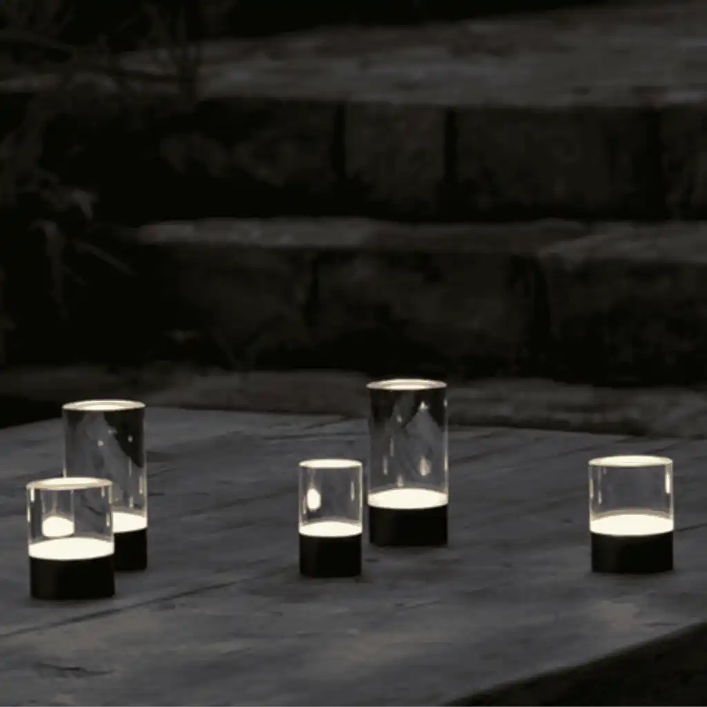 Useita Uyuni Glow Rod -valoputkia luomassa tunnelmaa ulkopöydällä pimeässä – IP44 säänkestävä