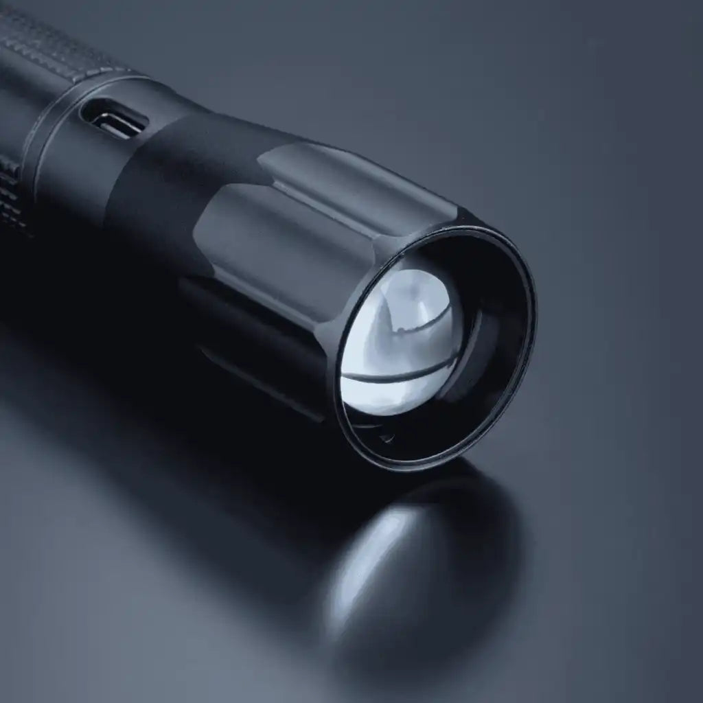Lähikuva Optima Medium -taskulampun linssistä ja säädettävästä zoom-valokeilasta