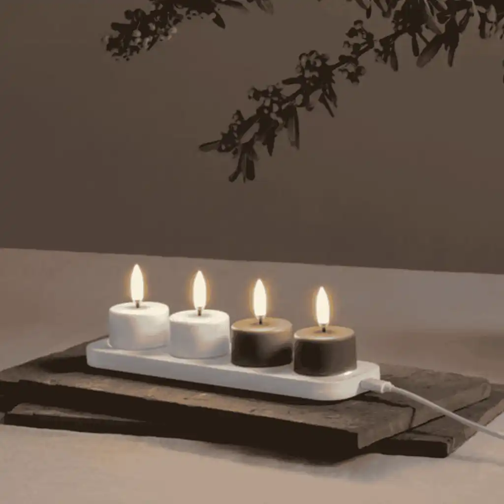 Neljä Uyuni LED-kynttilää latautumassa pienellä Uyuni-latausalustalla – kätevä liikelahjasetti