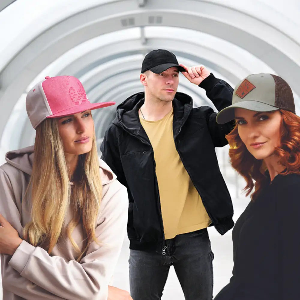 Kolme henkilöä, jotka ovat pukeutuneet rentoihin vaatteisiin ja baseball-lippiksiin.