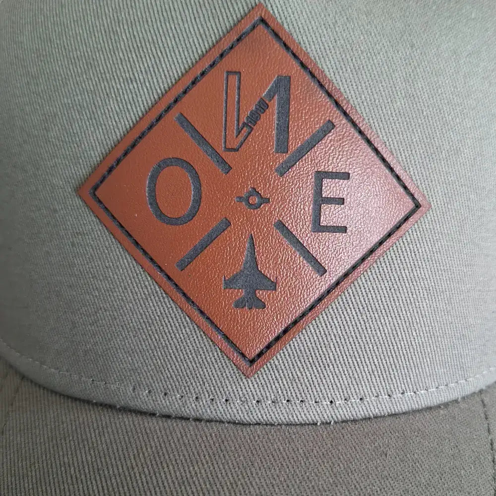 Lähikuva nahkamerkistä lippalakki omalla logolla. Avuksi suunnittelemaa oma logo lippis