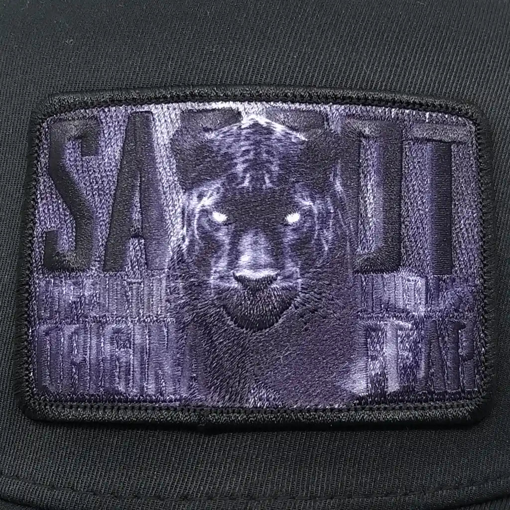 Sabbot Wolf – miesten lippalakki, kirjailtu Pantteri-badge lähikuvassa