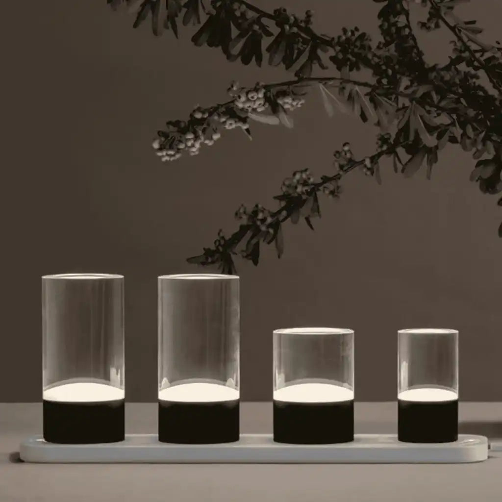 Neljä Uyuni LED-kynttilää latautumassa pienellä Uyuni-monilaturilla – lisävaruste Glow Rod -valoputkille